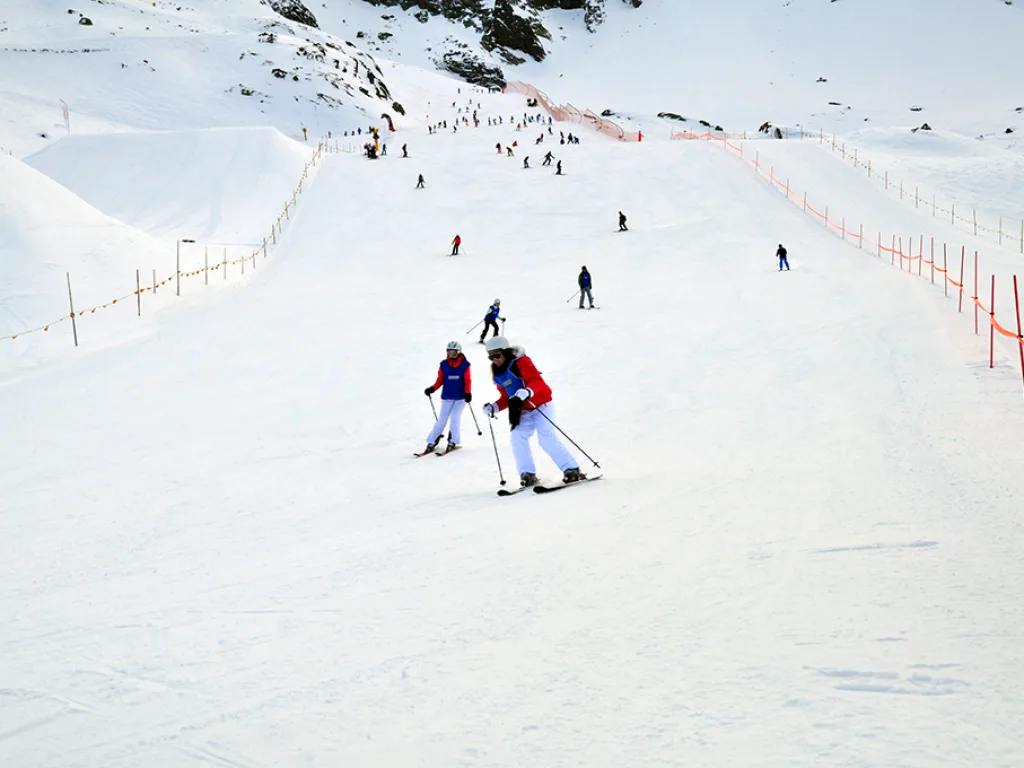 Skifahrende auf der weiten Piste.